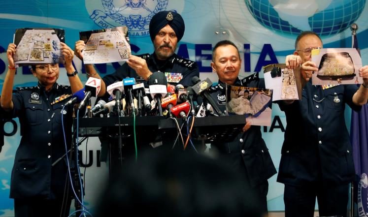 الشرطة الماليزية خلالها عرضها بمؤتمر صحفي جانبا من الممتلكات المصادرة (رويترز)