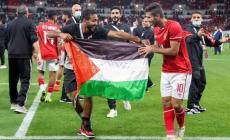 لاعبا الأهلي يرفعان العلم الفلسطيني