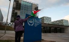 فلسطيني يرفع العلم أمام مقر محكمة الجنايات