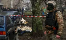 جندي يقف بالقرب من الجثث في الموقع الذي سقطت فيه الطائرة المروحية (رويترز)