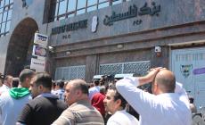 موظفو السلطة خلال تقاضيهم لرواتبهم من بنك فلسطين 