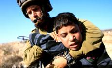جندي اسرائيلي يعتقل طفل فلسطيني
