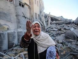 صورة لوالدة العروس، تقف أمام حطام منزلها في مدينة غزة