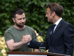 ماكرون (يمين) يصافح زيلينسكي خلال زيارته الأخيرة إلى كييف تأكيدا لدعمه لأوكرانيا (غيتي)