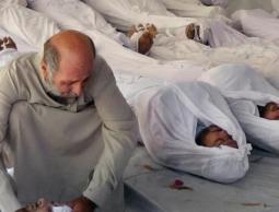 رجل سوري محاط بجثث ضحايا قصف بالغازات السامة على مدينة دوما بريف دمشق