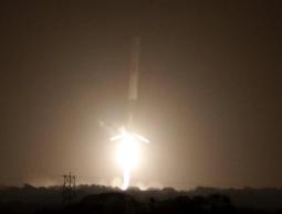 فالكون 9 قبيل لحظات من هبوطه الناجح على الأرض بعد عودته من عملية إطلاق أقمار صناعية ناجحة