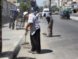 عمال ينظفون أحد الشوارع في غزة (الأرشيف)