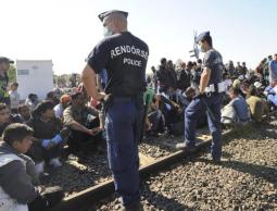 عناصر أمن مجريون يحرسون لاجئين وصلوا من صربيا إلى المجر (الأوروبية)