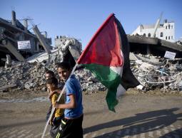 طفل يحمل علم فلسطين في حي الشجاعية بغزة