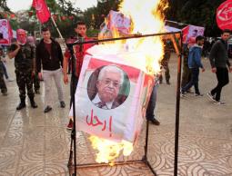 عناصر من الشعبية يحرقون صور الرئيس عباس