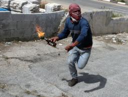 شاب فلسطيني يلقي زجاجة حارقة على الاحتلال (أرشيف)