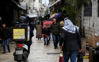 فلسطينيون يتجولون في الشوارع خلال يوم ممطر في نابلس
