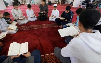 فتية يقرؤون القرآن داخل أحد المساجد في دير البلح