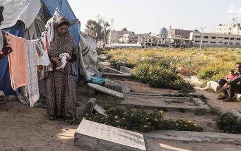 نازح يعيش مع أسرته في خيمة داخل مقبرة بدير البلح