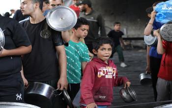 نازحون يتجمعون للحصول على القليل من الطعام بمخيم النصيرات