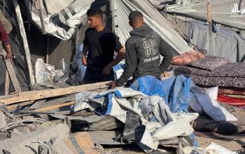 فلسطينيون يتفقدون آثار غارة إسرائيلية وسط ركام المنازل والخيام الممزقة