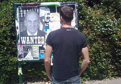  صهيوني ينظر لإعلان وضعت عليه صورة 