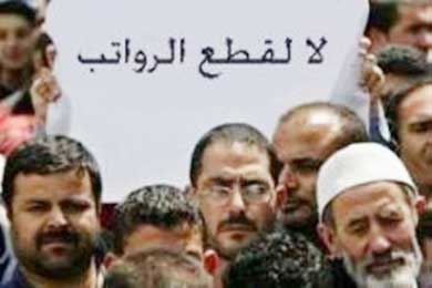 موظفون يدعون خلال مسيرة في مدينة غزة لعدم قطع الرواتب 