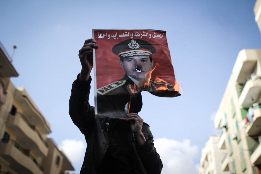 متظاهرون يحرقون صورة السيسي 