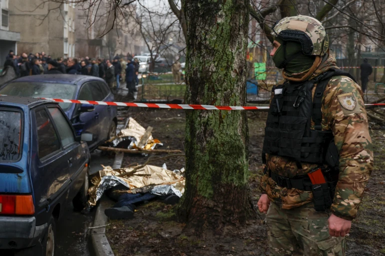 جندي يقف بالقرب من الجثث في الموقع الذي سقطت فيه الطائرة المروحية (رويترز)
