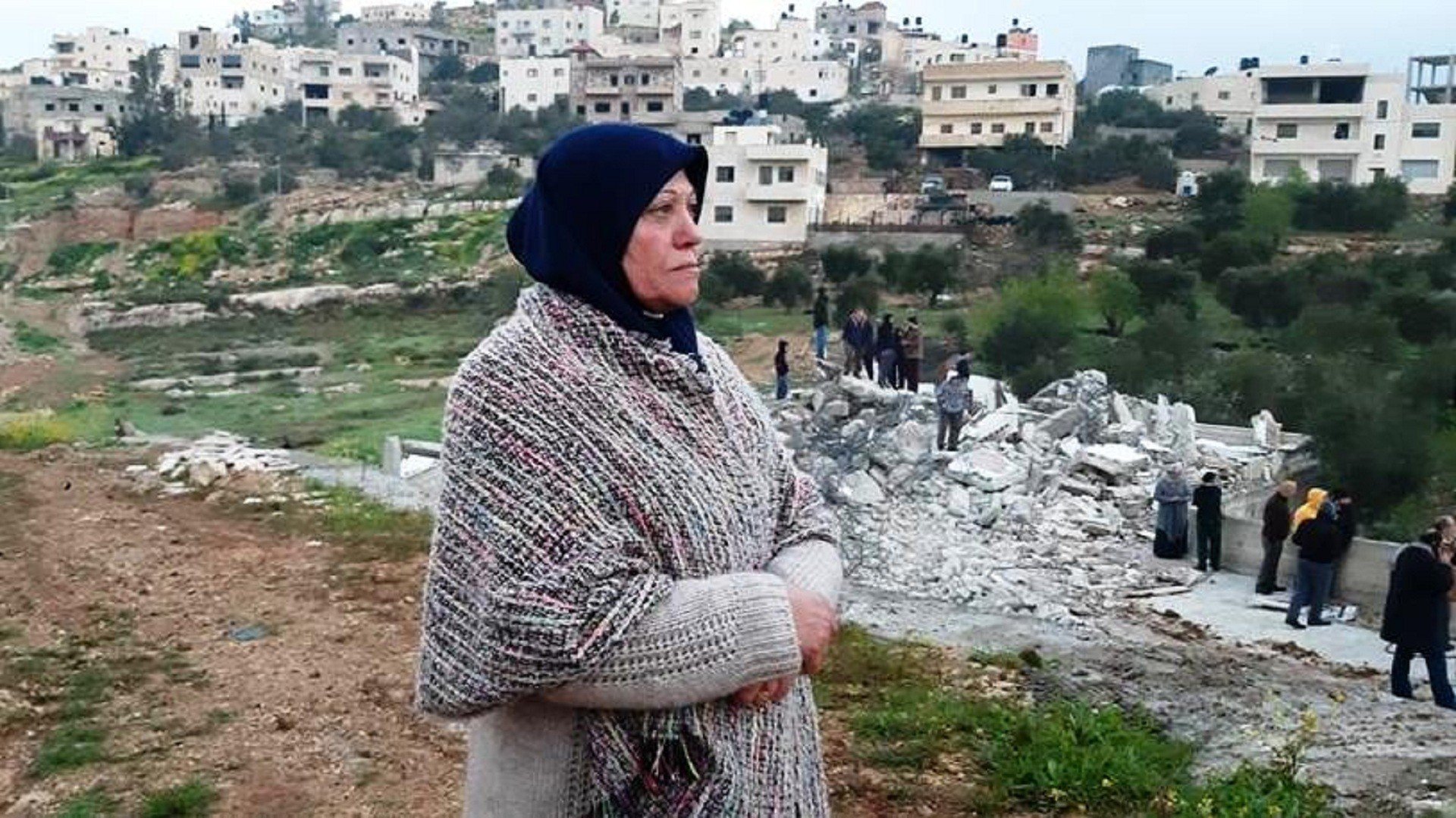 ام عاصف البرغوثي أمام منزل ابنها الأسير المهدم من قبل الاحتلال