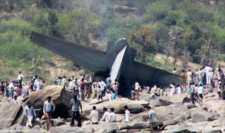 سكان محليون يتجمعون حول بقايا طائرة شحن تابعة للجيش من طراز سي-130 سقطت وسط الهند عام 2014 (رويترز)