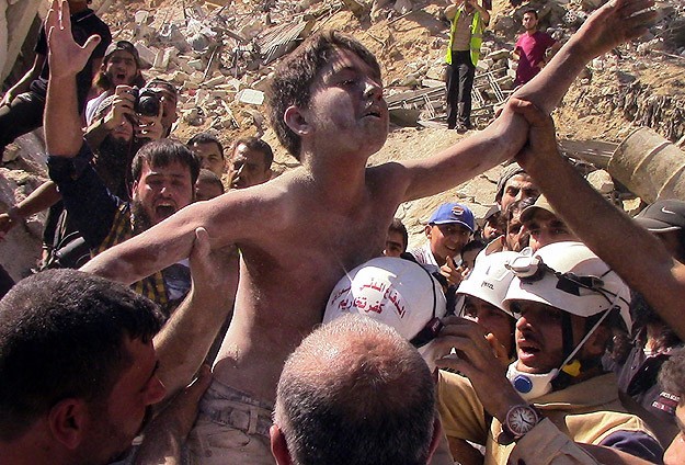اخراج طفل من تحت الأنقاض في قصف بسوريا (أرشيف)