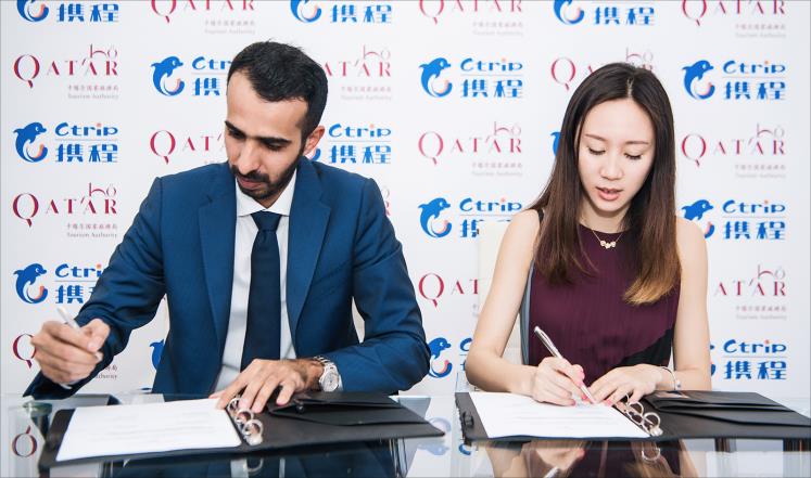 راشد القريصي يوقع الاتفاقية مع مسؤولة في شركة "سي تريب" وهي أكبر منصة إلكترونية للخدمات السياحية بالصين (الجزيرة)