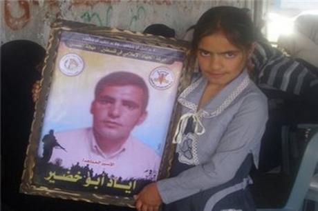 إبنة الأسير إياد أبو خضير تحمل صورة والدها(الأرشيف)