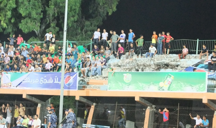 الجماهير تجلس على المدرجات المقصوفة بالرغم من خطورتها