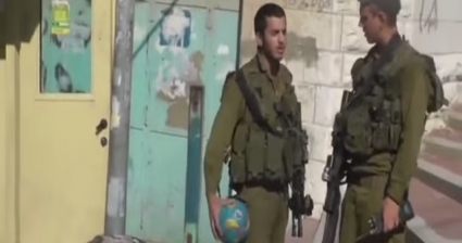 الجندي الإسرائيلي ينتزع الكرة من الأطفال
